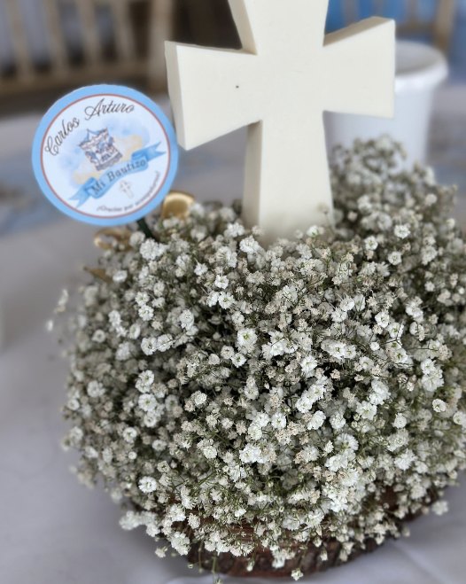 Centro de mesa de bautizo con cruz de cera blanca y nube de flores
